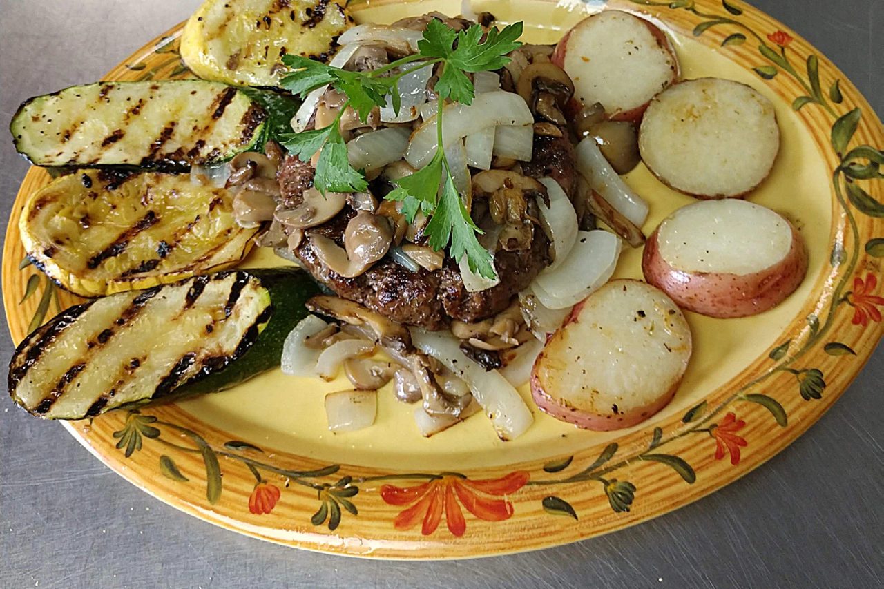 Chopped sirloin topped with sautéed mushrooms and onions, with grilled squash and potatoes